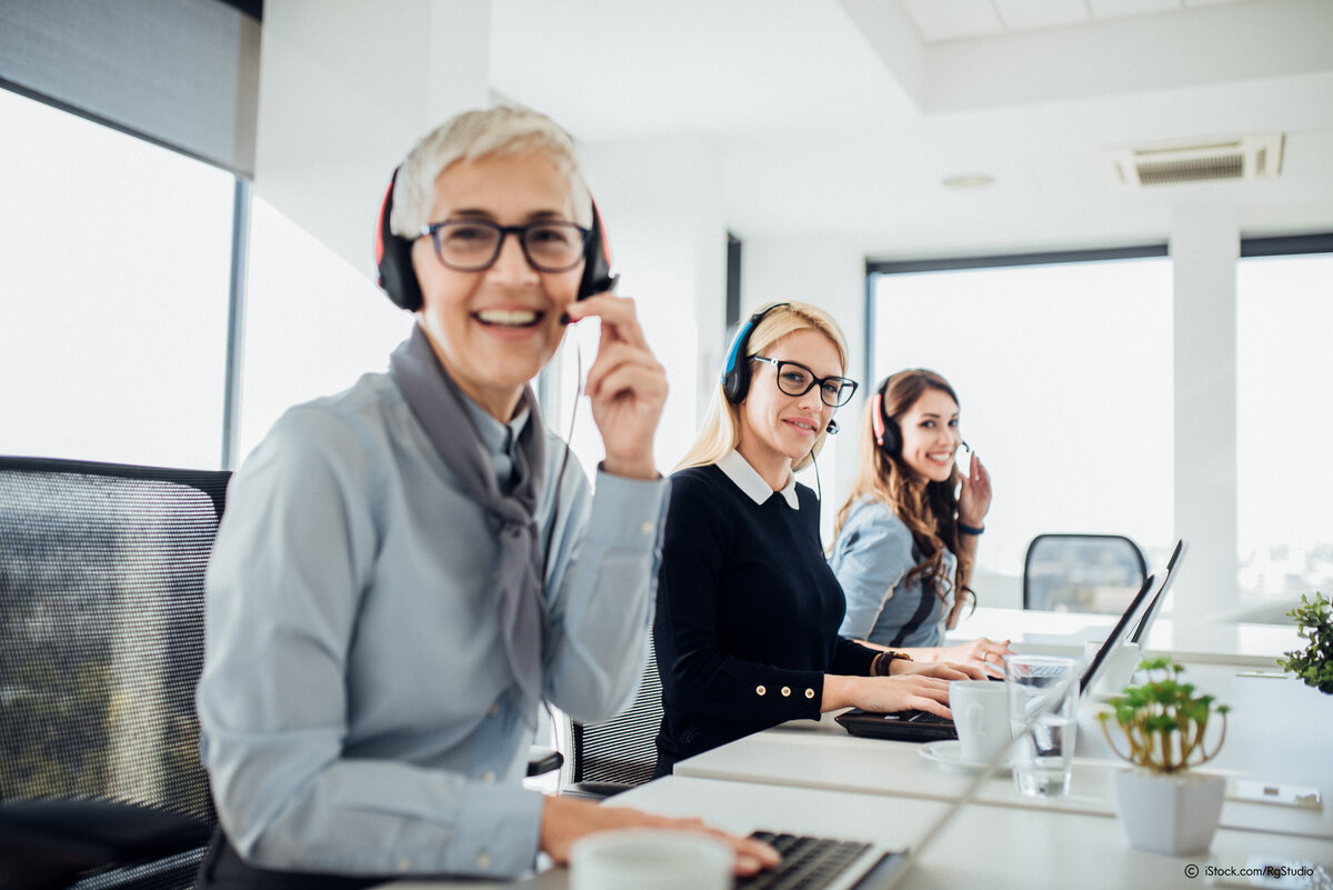 Glücklich Reife Frau mit Kopfhörer arbeitet in einem Call-Center